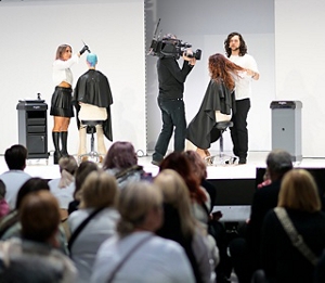 Two stylists working on hair on-stage